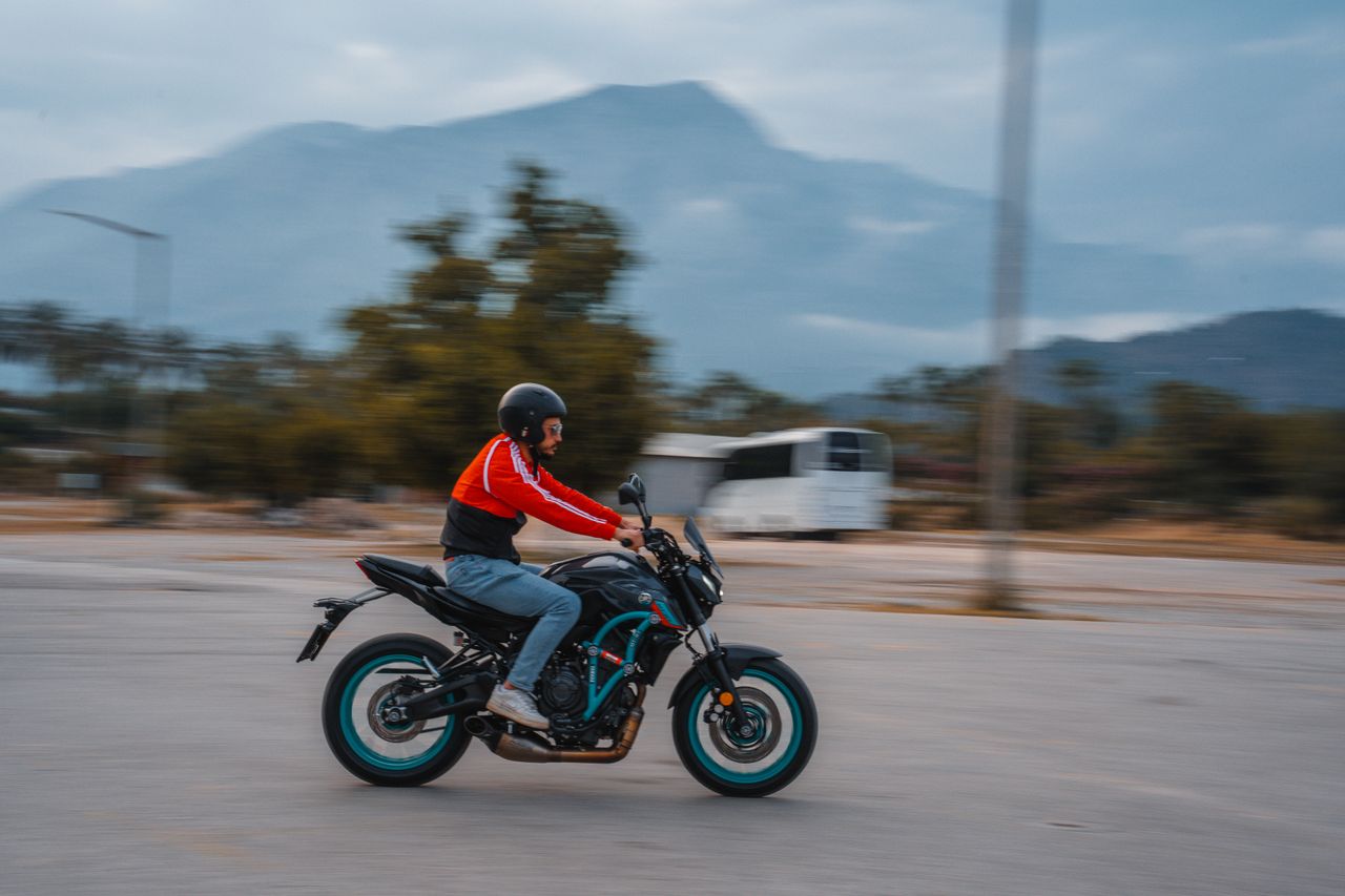 A motorcyclist rides through the scenic landscape of Kemer, Antalya, Türkiye.