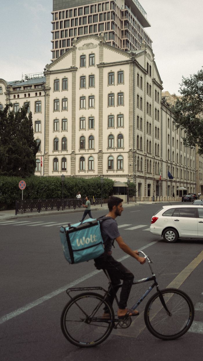 Food delivery cyclist in Baku, Azerbaijan cityscape background.
