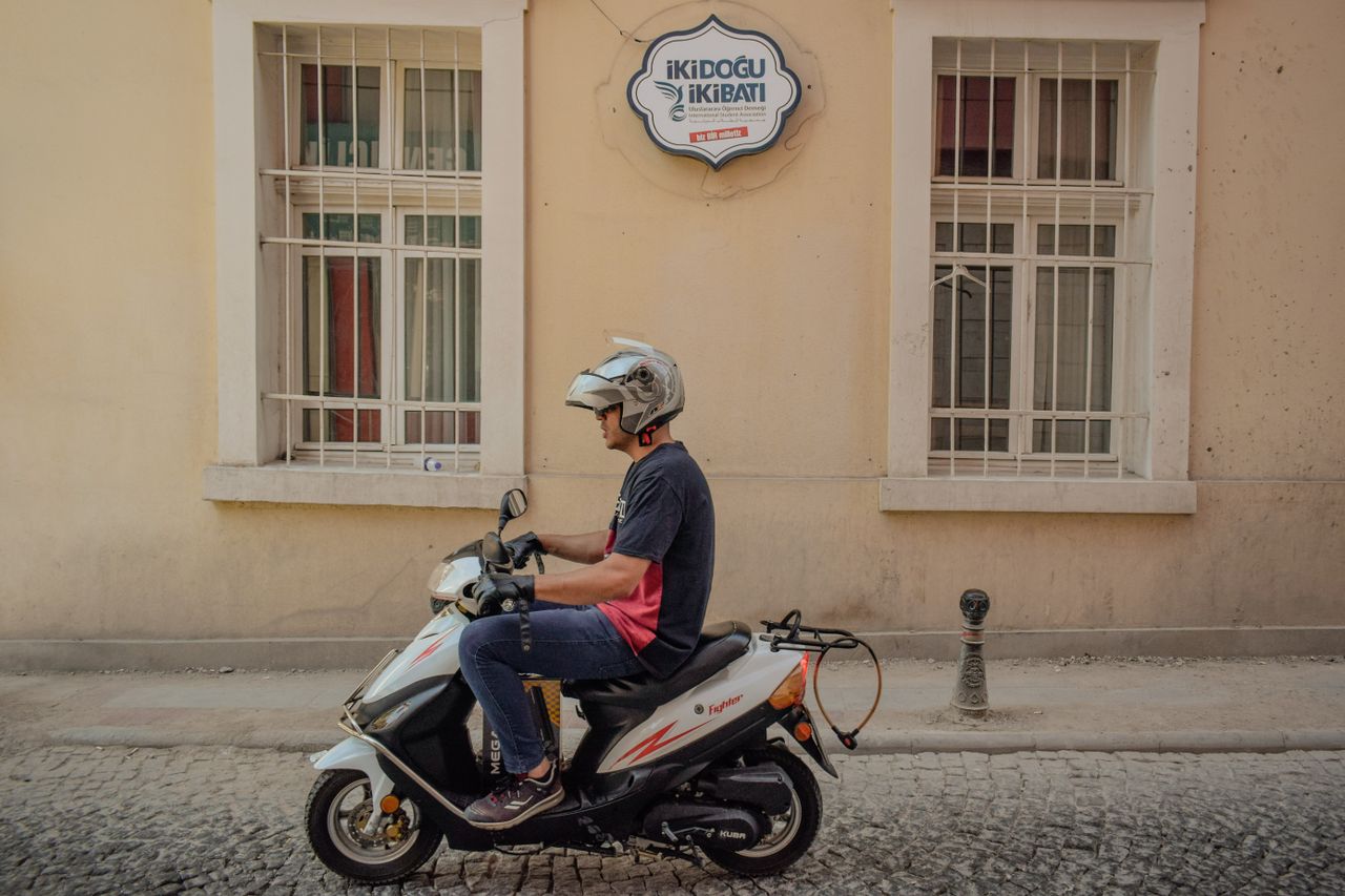 A man rides a motor scooter through Konya, showcasing urban life in Türkiye.